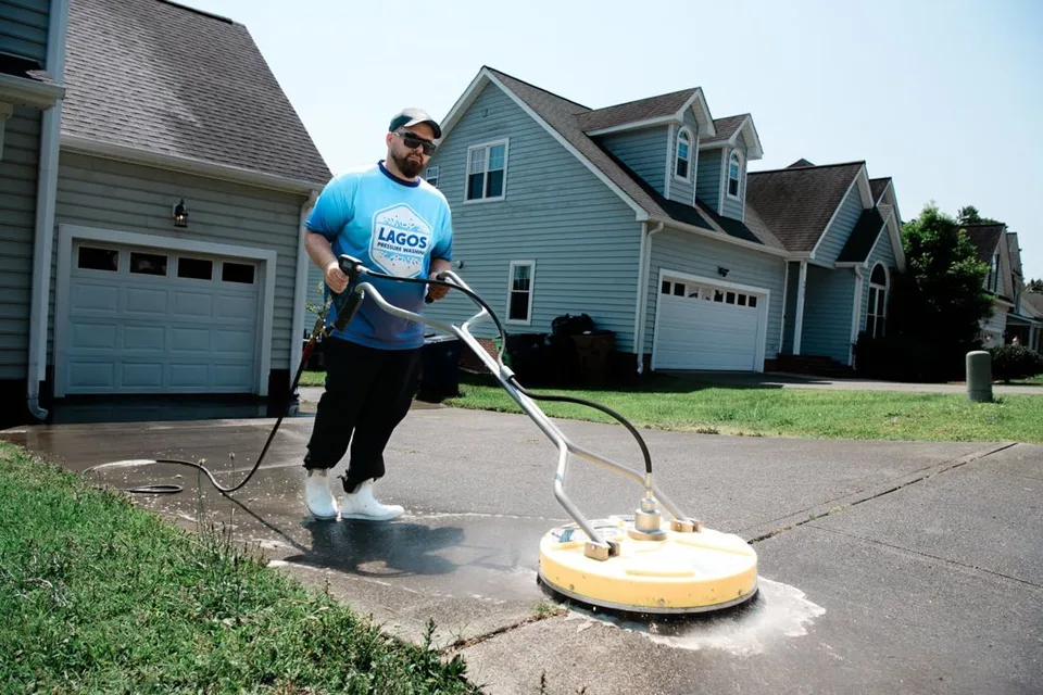 Lagos technician using a surface cleaner on a driveway