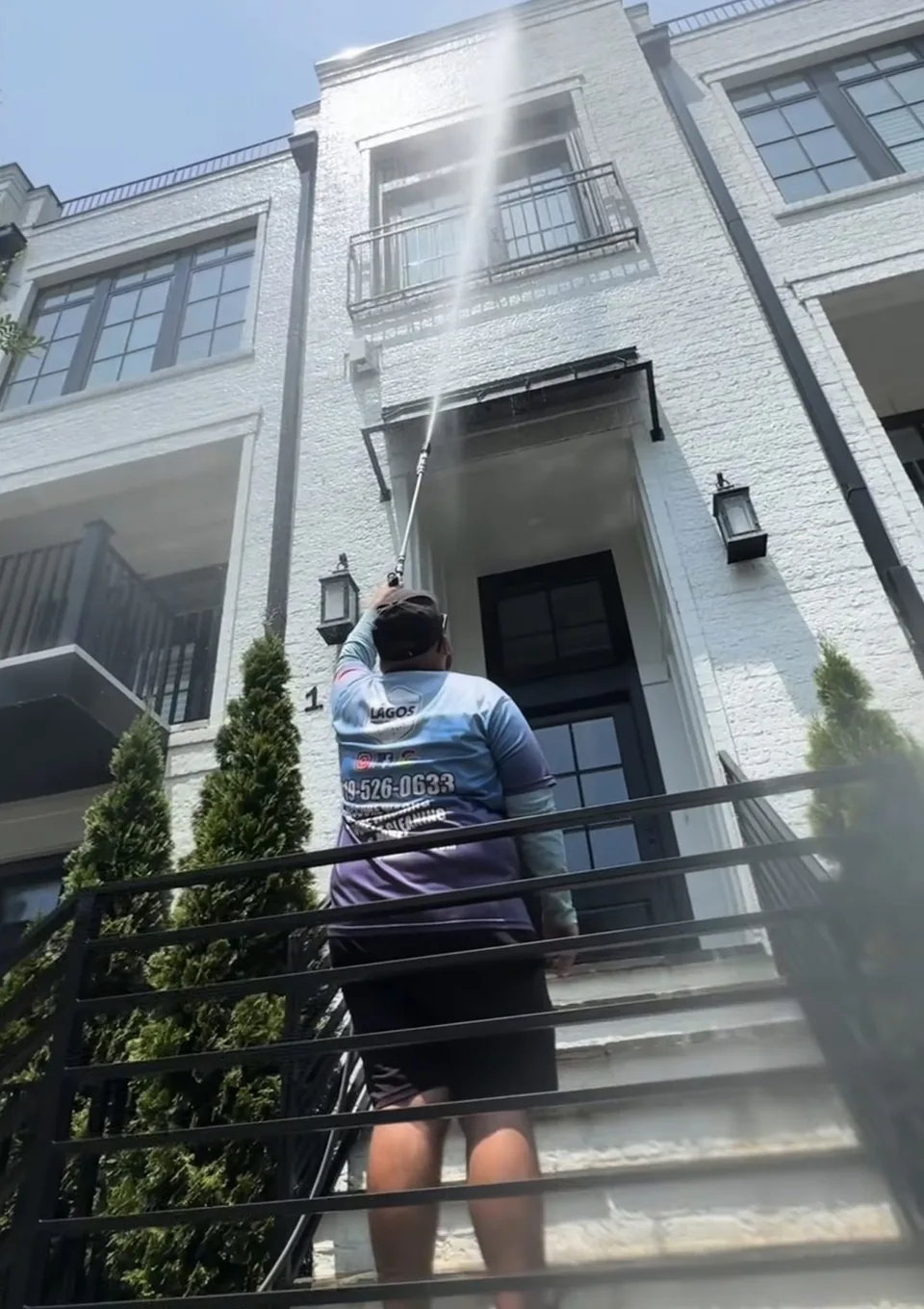 Lagos technician washing the siding and trim of a home